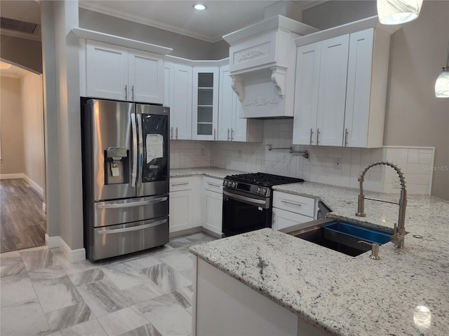 kitchen featuring white cabinetry, sink, light stone counters, stainless steel refrigerator with ice dispenser, and black gas stove