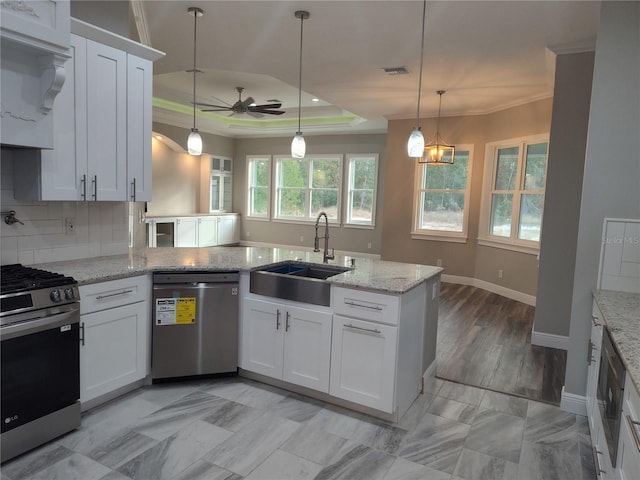 kitchen with white cabinets, pendant lighting, stainless steel appliances, and ceiling fan