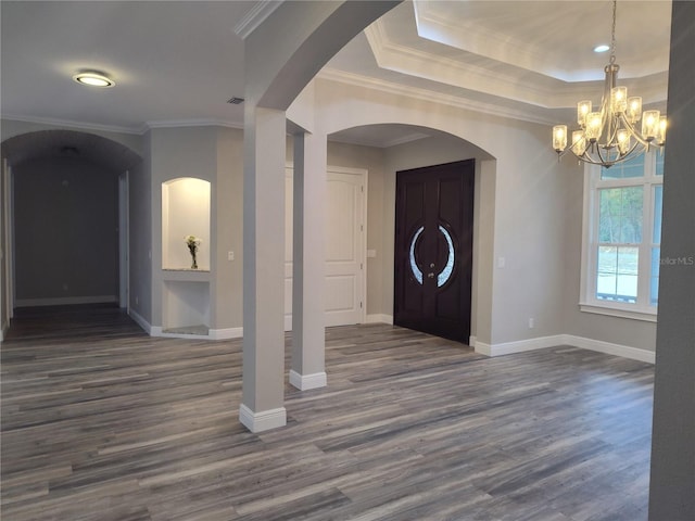 foyer featuring ornamental molding, dark wood-type flooring, and a chandelier