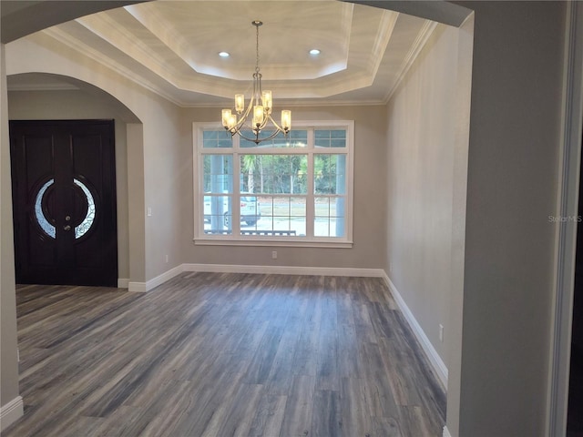 interior space featuring a raised ceiling, crown molding, dark hardwood / wood-style flooring, and a chandelier