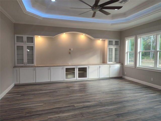 spare room featuring ceiling fan, crown molding, dark wood-type flooring, and a tray ceiling