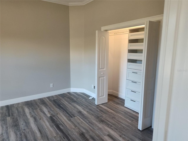 unfurnished bedroom with a closet, dark hardwood / wood-style floors, and ornamental molding