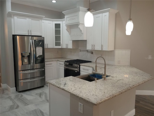 kitchen featuring sink, kitchen peninsula, appliances with stainless steel finishes, decorative light fixtures, and white cabinetry