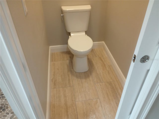 bathroom with toilet and wood-type flooring