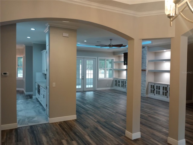 interior space with french doors, ornamental molding, ceiling fan, built in features, and dark hardwood / wood-style floors