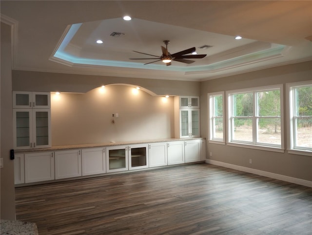 spare room with a raised ceiling, ceiling fan, dark hardwood / wood-style flooring, and ornamental molding