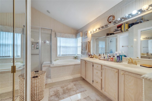 bathroom with tile patterned floors, vanity, separate shower and tub, and vaulted ceiling