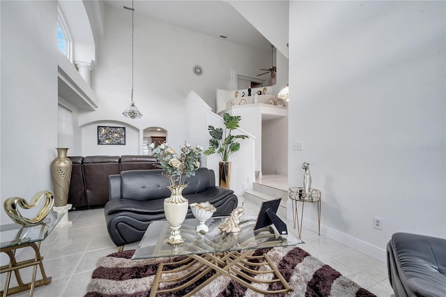 tiled living room with a towering ceiling and ceiling fan