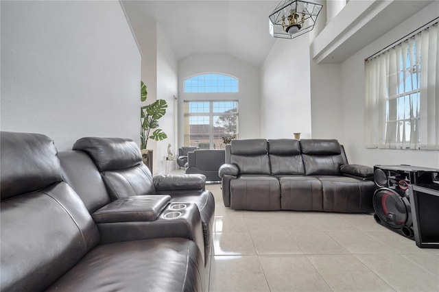 tiled living room featuring an inviting chandelier and vaulted ceiling