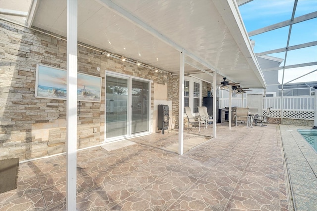 view of patio / terrace featuring glass enclosure, ceiling fan, and a swimming pool