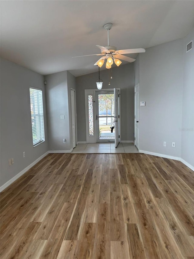 unfurnished living room with ceiling fan, hardwood / wood-style floors, and lofted ceiling