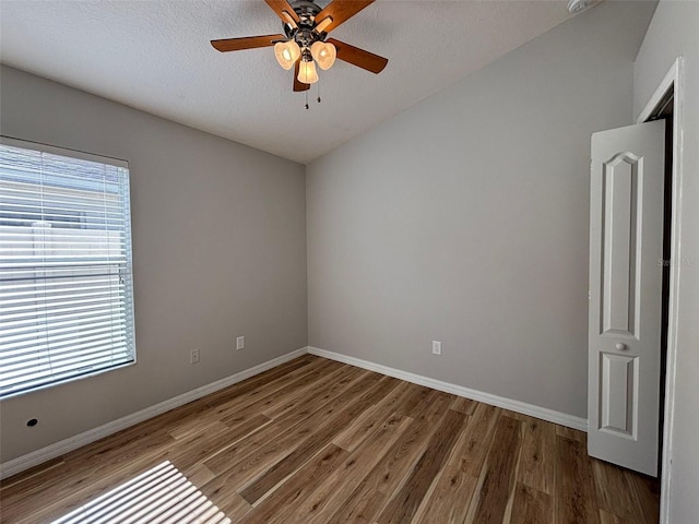 unfurnished room featuring dark hardwood / wood-style floors, ceiling fan, and a textured ceiling