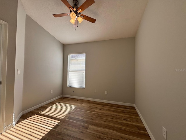 spare room featuring a textured ceiling, ceiling fan, vaulted ceiling, and dark hardwood / wood-style floors