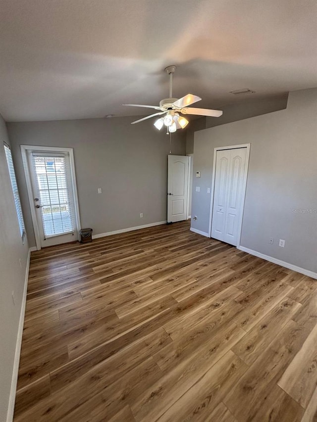 unfurnished bedroom with hardwood / wood-style floors, ceiling fan, and a closet