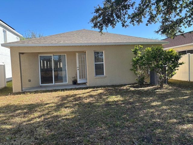 back of property featuring a yard