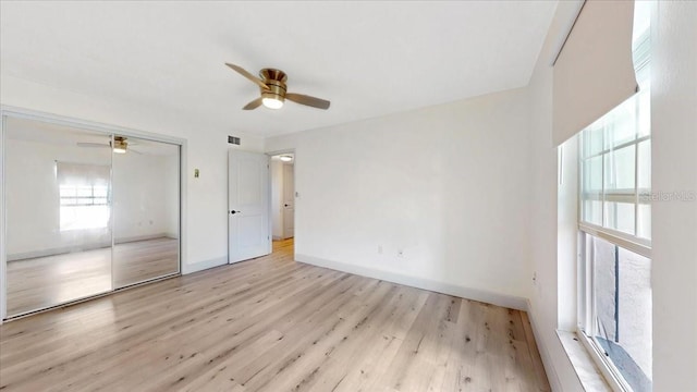 unfurnished bedroom with light wood-type flooring, a closet, and ceiling fan