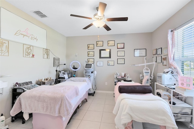 tiled bedroom featuring ceiling fan and multiple windows