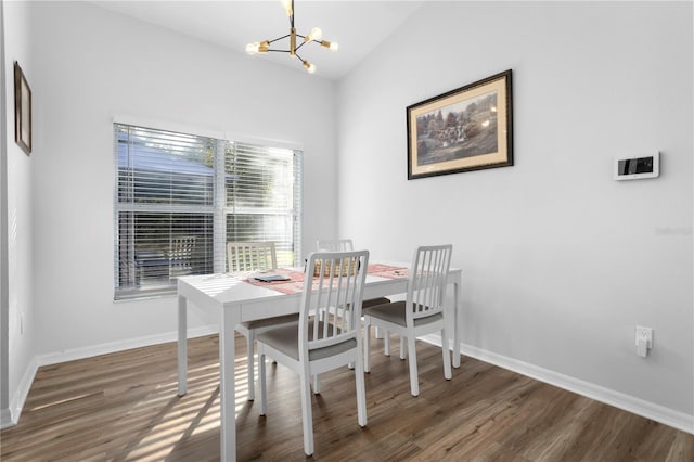 dining area featuring dark hardwood / wood-style flooring, lofted ceiling, and a chandelier