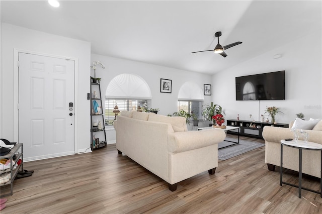 living room featuring hardwood / wood-style floors, vaulted ceiling, and ceiling fan