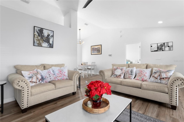 living room featuring dark hardwood / wood-style floors and vaulted ceiling