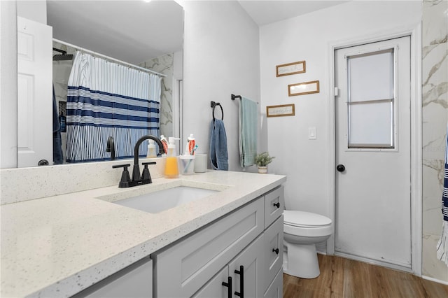 bathroom with wood-type flooring, vanity, toilet, and a shower with curtain