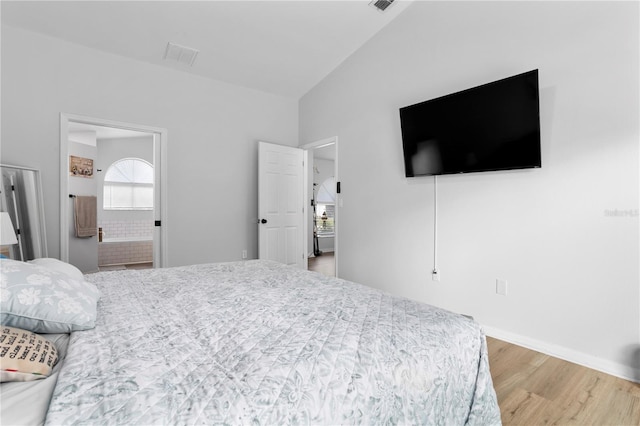 bedroom featuring connected bathroom and hardwood / wood-style floors