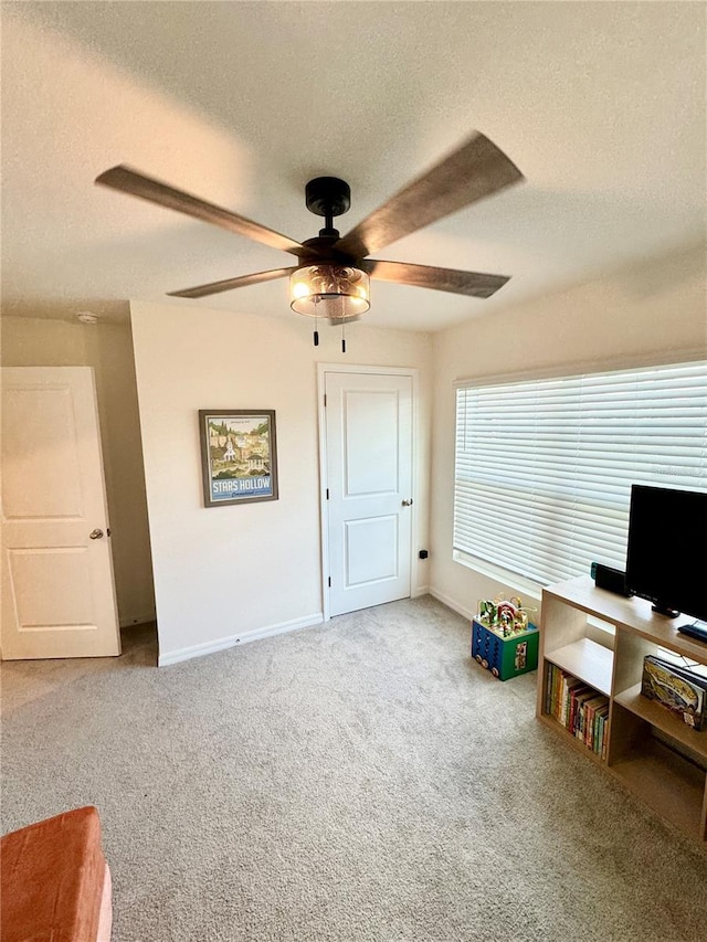 game room featuring ceiling fan, carpet, and a textured ceiling