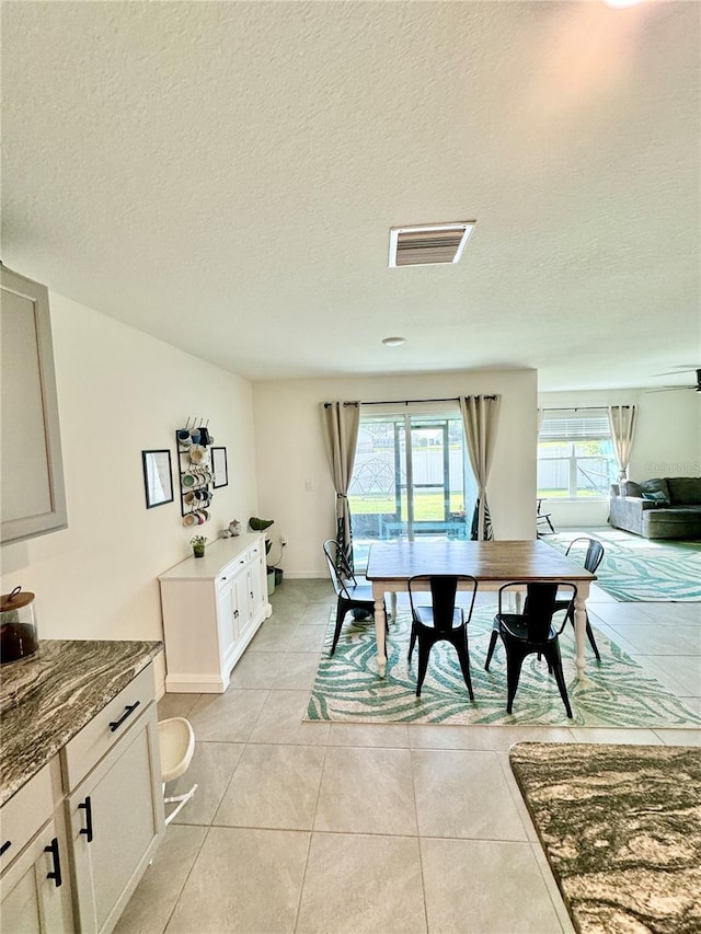 dining room with light tile patterned flooring and a textured ceiling