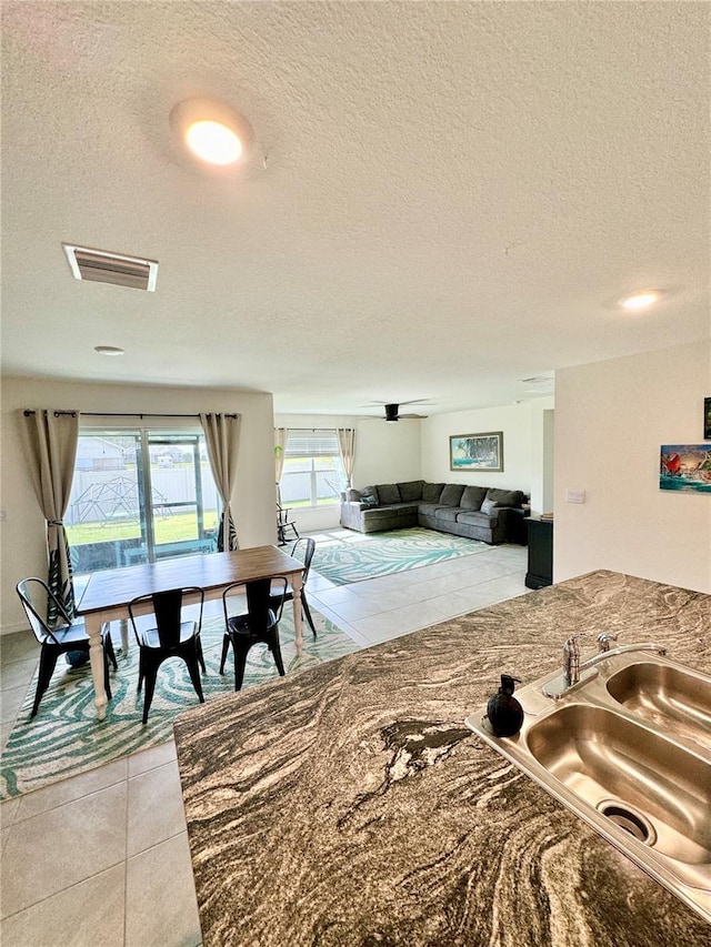 kitchen featuring sink, a textured ceiling, and light tile patterned floors