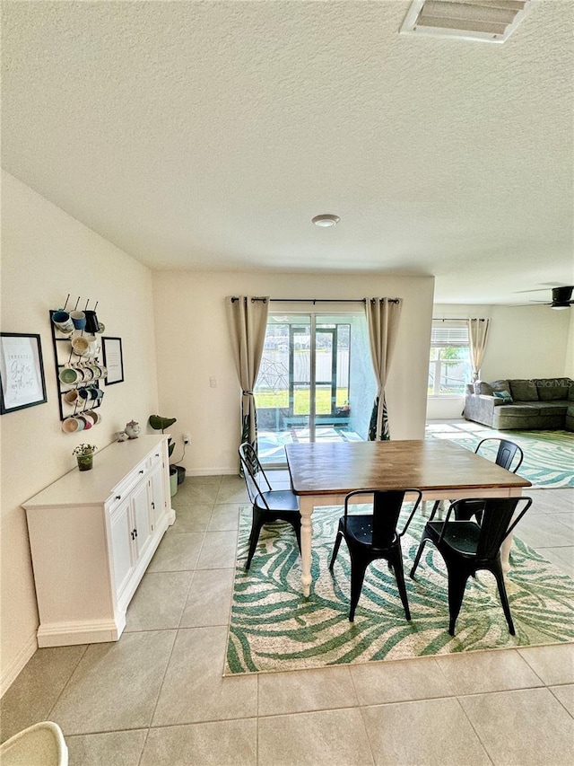 dining area featuring plenty of natural light, light tile patterned floors, and a textured ceiling