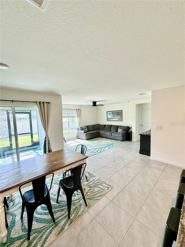 dining room with ceiling fan, light tile patterned floors, and a textured ceiling