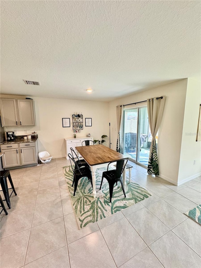 tiled dining room featuring a textured ceiling