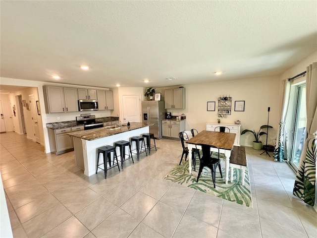 tiled dining room featuring sink and a textured ceiling