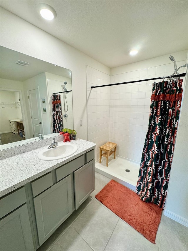 bathroom featuring walk in shower, tile patterned floors, vanity, and a textured ceiling