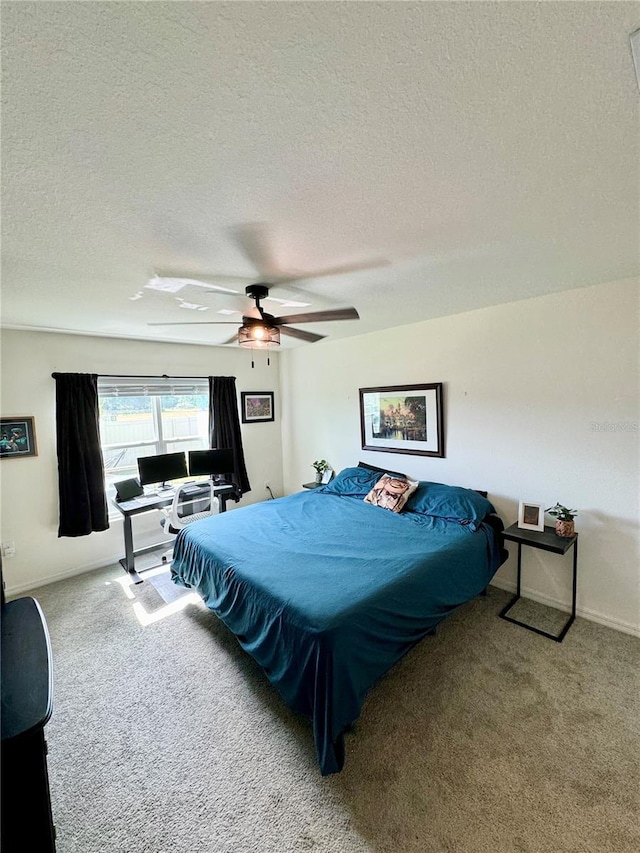 bedroom featuring a textured ceiling, ceiling fan, and carpet flooring