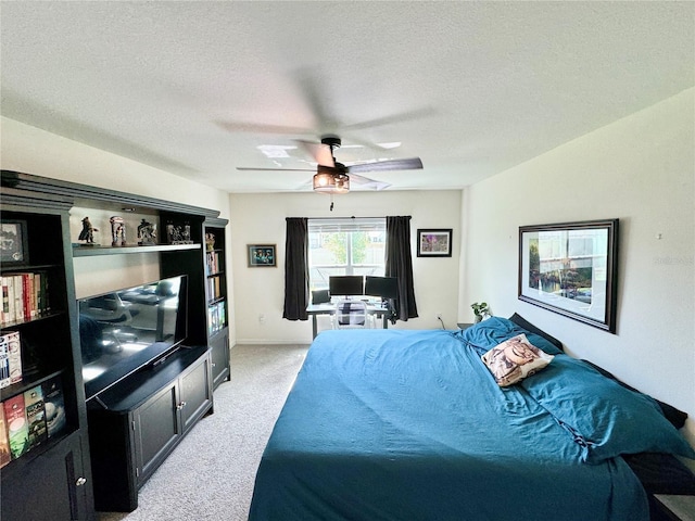 carpeted bedroom with ceiling fan and a textured ceiling