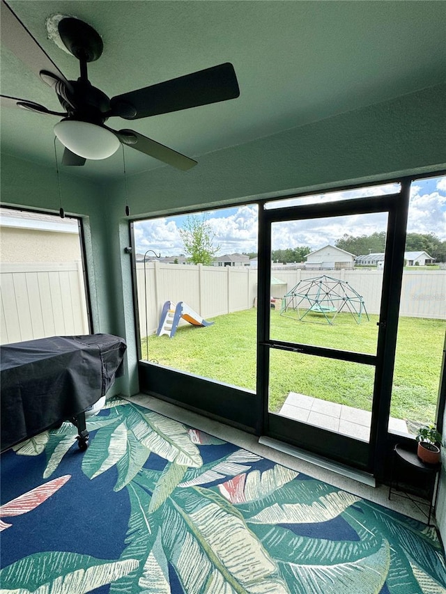 sunroom with a healthy amount of sunlight and ceiling fan