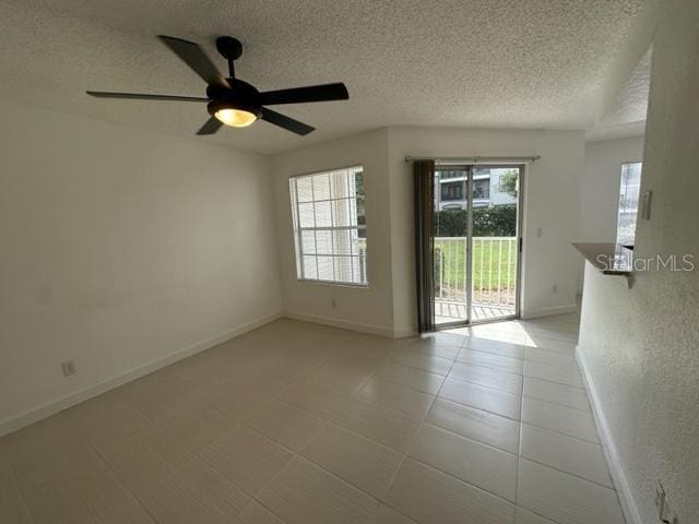 spare room with a textured ceiling and ceiling fan