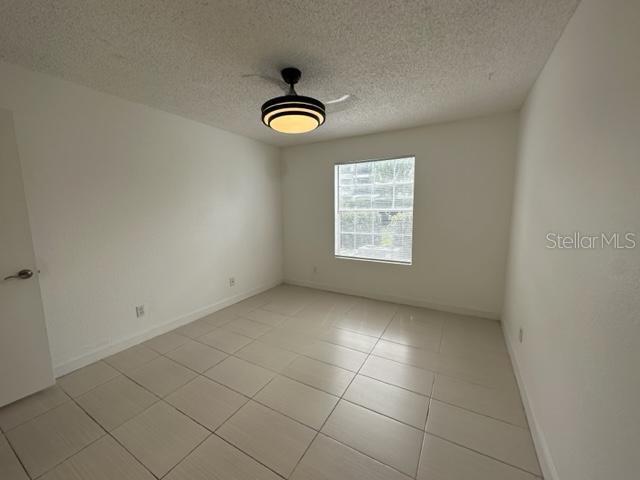 empty room featuring light tile patterned floors and a textured ceiling