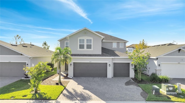 view of property featuring a garage and a front lawn