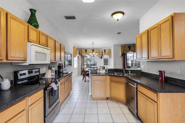 kitchen featuring sink, a notable chandelier, pendant lighting, light tile patterned floors, and appliances with stainless steel finishes