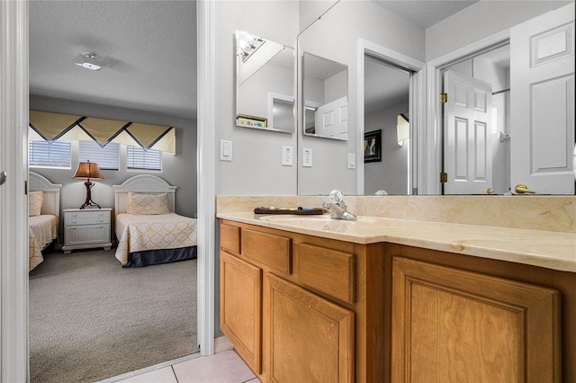 bathroom with tile patterned flooring, vanity, and a textured ceiling