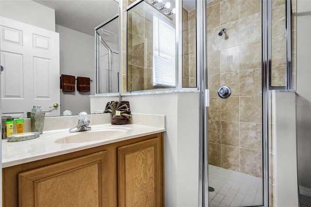 bathroom featuring vanity, a textured ceiling, and walk in shower