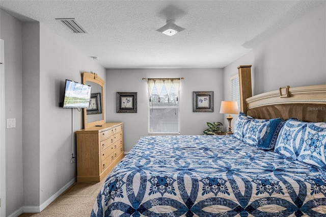 bedroom with light colored carpet and a textured ceiling