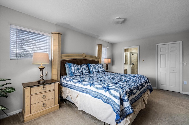 carpeted bedroom with a textured ceiling and connected bathroom