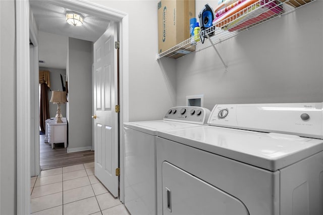 laundry room featuring separate washer and dryer and light hardwood / wood-style flooring