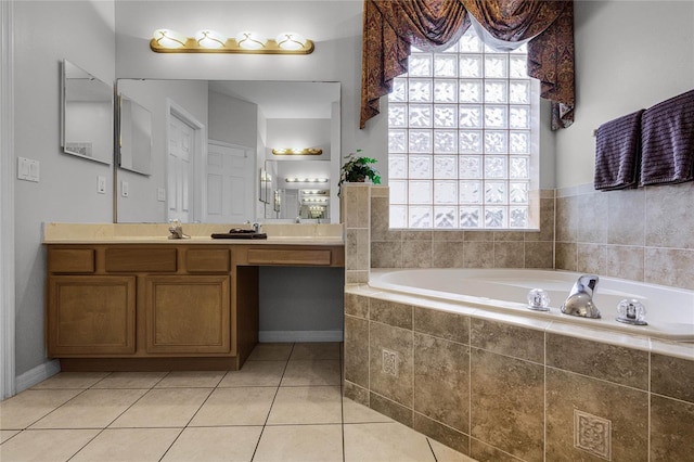 bathroom with vanity, tile patterned floors, a healthy amount of sunlight, and tiled tub