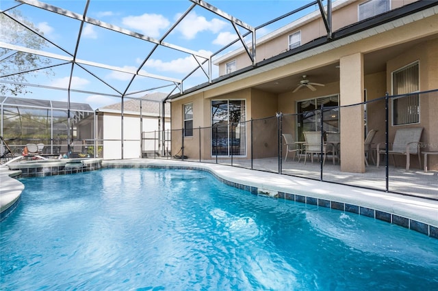 view of pool with a lanai, ceiling fan, a patio area, and an in ground hot tub