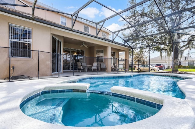 view of swimming pool with a patio area, an in ground hot tub, ceiling fan, and glass enclosure