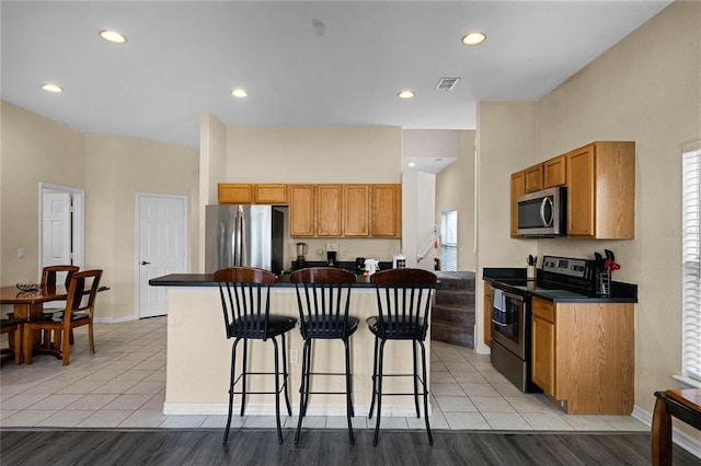 kitchen with a wealth of natural light, light hardwood / wood-style flooring, and stainless steel appliances